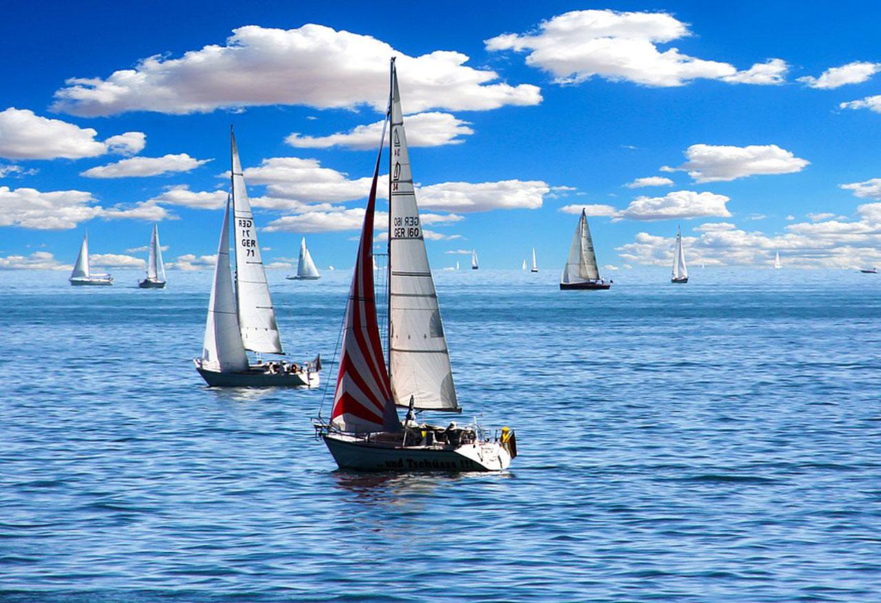 Voiliers glissant sur une mer calme, symbole de la traversée